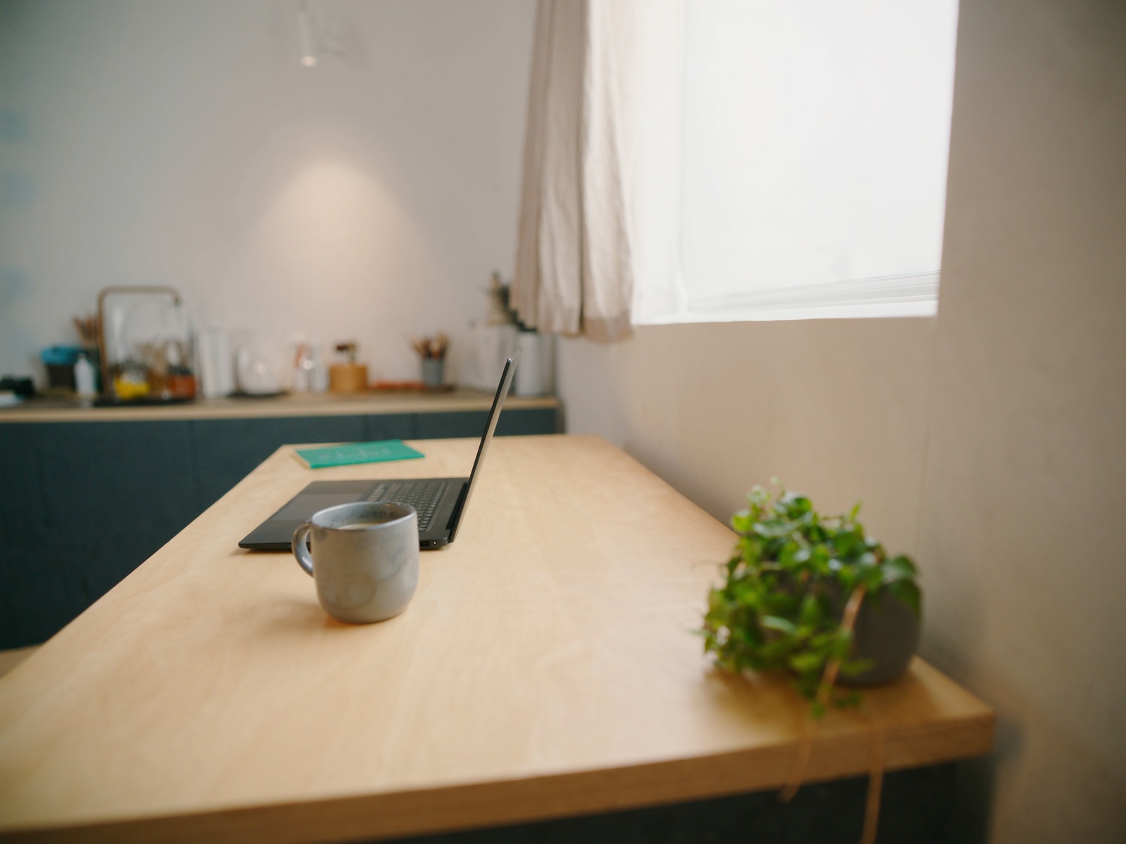 A remote workspace with a laptop beside a sunlit window